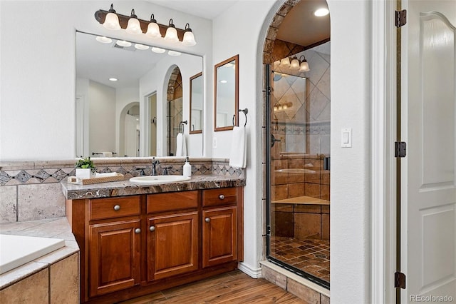2832 Danbury Ave, Highlands Ranch, CO 80126 - full bathroom with vanity, a stall shower, wood finished floors, and a garden tub
