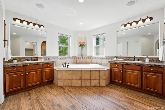 2832 Danbury Ave, Highlands Ranch, CO 80126 - full bathroom featuring two vanities, a bath, wood finished floors, and recessed lighting