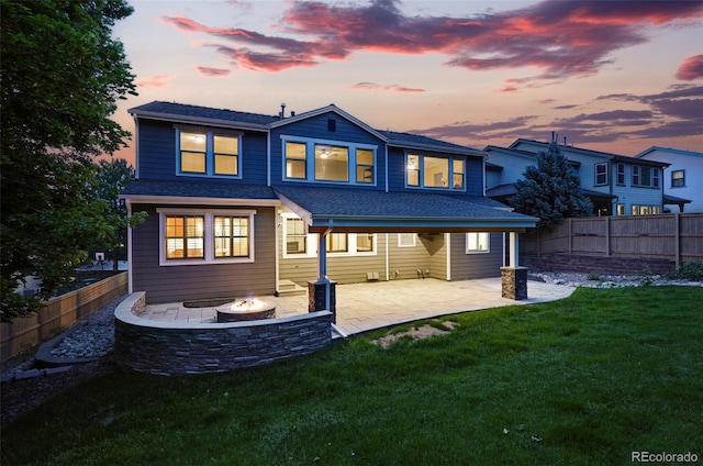 2832 Danbury Ave, Highlands Ranch, CO 80126 - back of house at dusk with an outdoor fire pit, a patio, and roof with shingles