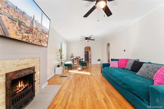 511 S Pennsylvania St, Denver, CO 80209 - living area featuring arched walkways, ceiling fan, wood finished floors, and a tile fireplace