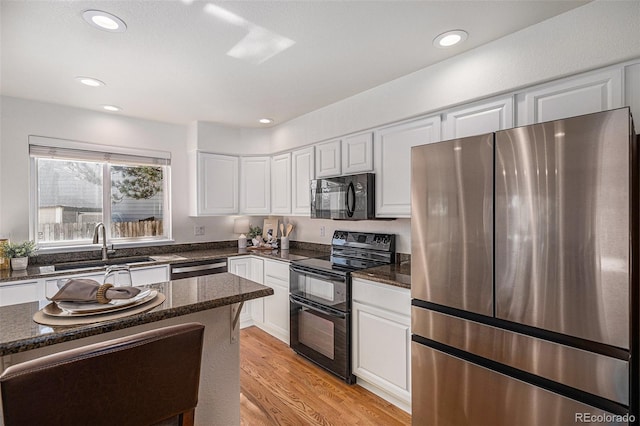 8825 Fairview Oaks Pl, Lone Tree, CO 80124 - kitchen featuring black appliances, white cabinetry, dark stone counters, light wood-style flooring, and recessed lighting