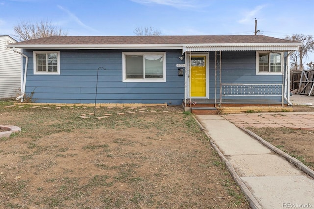 single story home featuring fence, covered porch, and a shingled roof