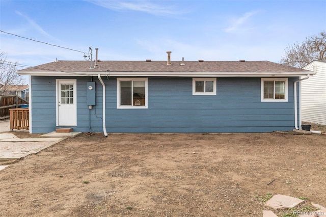 rear view of house with roof with shingles