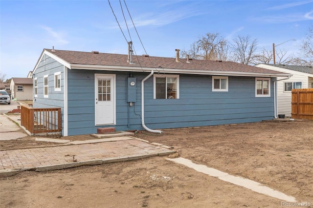 rear view of property featuring fence and entry steps