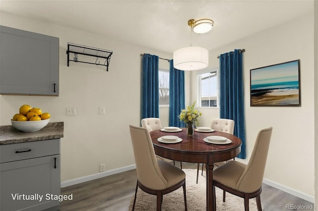 dining space with baseboards and wood finished floors