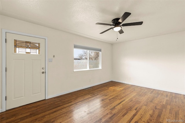 entryway featuring a textured ceiling, visible vents, baseboards, ceiling fan, and wood finished floors