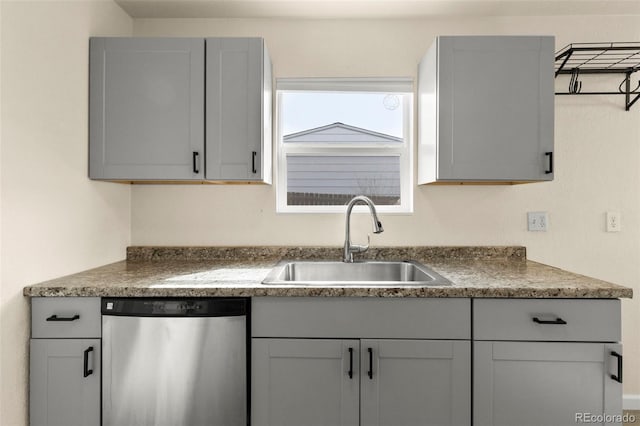 kitchen featuring a sink, gray cabinets, dark countertops, and dishwasher