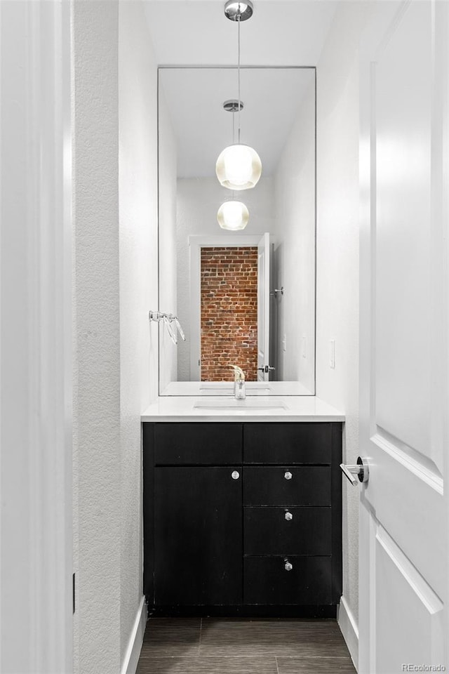 1211 E 26th Ave, Denver, CO 80205 - bathroom featuring vanity, wood finished floors, baseboards, and a textured wall