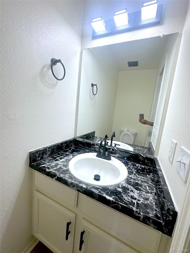 56 S Nome St, Aurora, CO 80012 - bathroom featuring vanity and a textured wall