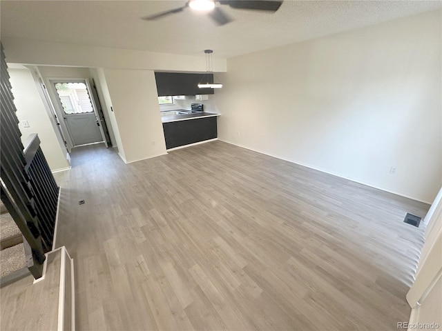 56 S Nome St, Aurora, CO 80012 - unfurnished living room featuring ceiling fan, light wood-style floors, and stairway