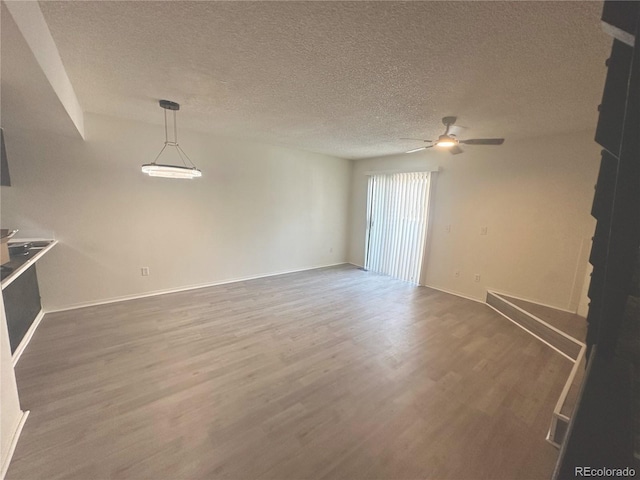 56 S Nome St, Aurora, CO 80012 - unfurnished living room with a ceiling fan, wood finished floors, and a textured ceiling