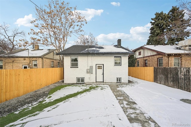 view of snow covered back of property