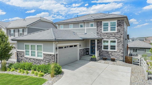 3453 Pacific Peak Dr, Broomfield, CO 80023 - view of front of home with stone siding, a garage, driveway, and a tile roof