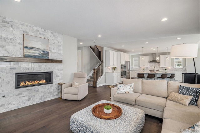 3453 Pacific Peak Dr, Broomfield, CO 80023 - living area featuring dark wood finished floors, a fireplace, stairs, and recessed lighting