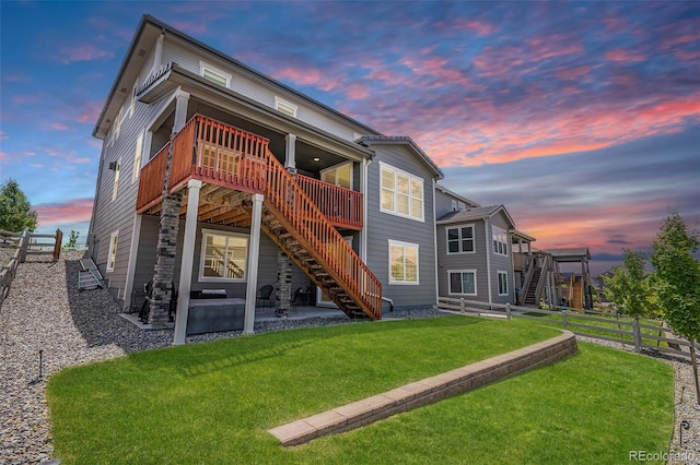 3453 Pacific Peak Dr, Broomfield, CO 80023 - back of property at dusk featuring stairs, a wooden deck, and a patio
