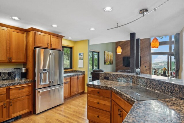 kitchen featuring light hardwood / wood-style floors, hanging light fixtures, plenty of natural light, and high end fridge