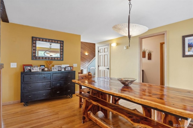 dining space featuring wood walls and light hardwood / wood-style flooring