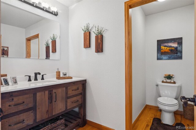 bathroom with vanity, hardwood / wood-style floors, and toilet