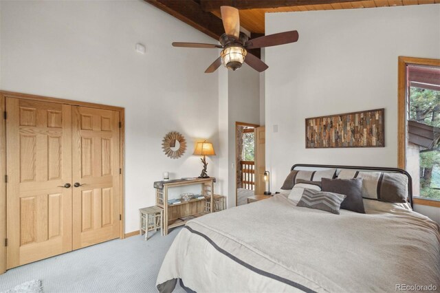 carpeted bedroom featuring high vaulted ceiling, ceiling fan, and beamed ceiling