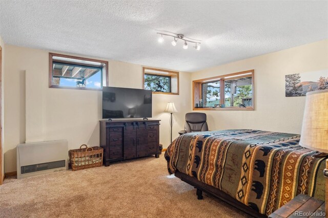 bedroom featuring a textured ceiling and light colored carpet