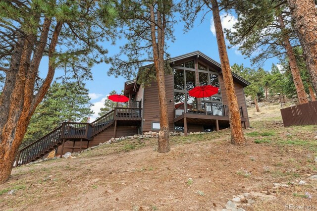 rear view of house featuring a wooden deck