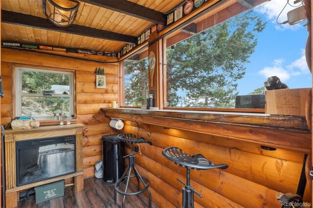 exterior space featuring wood ceiling, beam ceiling, rustic walls, and dark wood-type flooring