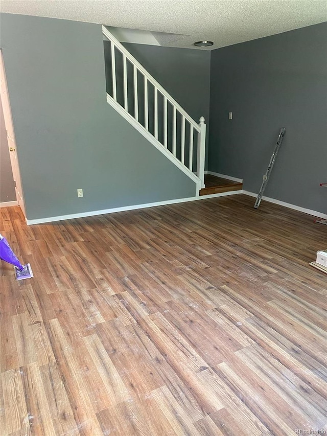 677 Vrain St Unit 3, Denver, CO 80204 - unfurnished living room with a textured ceiling, wood finished floors, baseboards, and stairs
