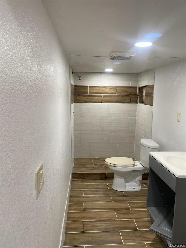 677 Vrain St Unit 3, Denver, CO 80204 - bathroom with toilet, vanity, visible vents, wood tiled floor, and a tile shower