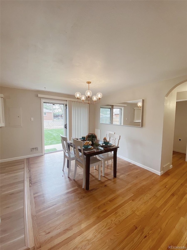 3000 Billings St, Aurora, CO 80011 - dining area featuring arched walkways, light wood-style floors, a chandelier, and baseboards