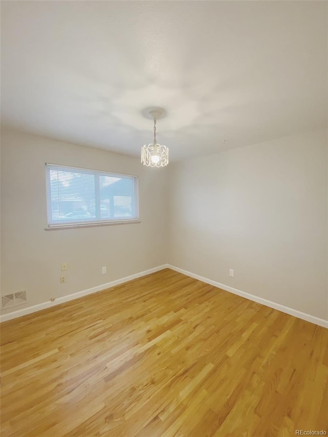 3000 Billings St, Aurora, CO 80011 - spare room featuring a chandelier, light wood-type flooring, and baseboards