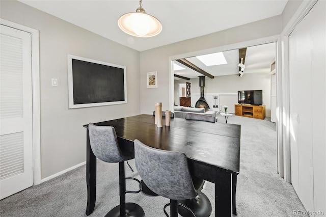 carpeted dining area with a wood stove