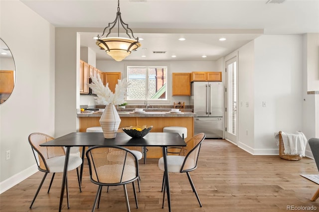 kitchen with recessed lighting, light wood-type flooring, baseboards, and high quality fridge