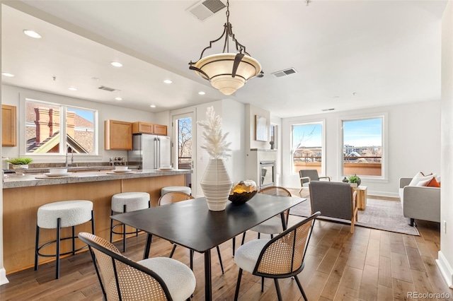 dining area with recessed lighting, visible vents, and light wood finished floors