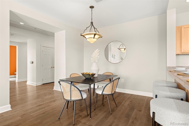 dining space with wood finished floors and baseboards