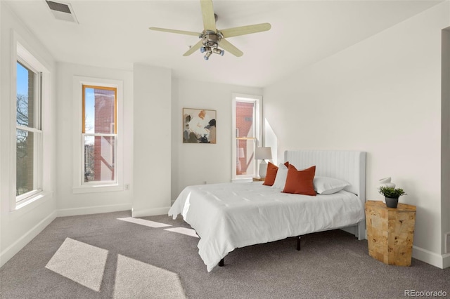 carpeted bedroom featuring visible vents, baseboards, and a ceiling fan