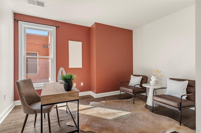 office space with visible vents, baseboards, and wood finished floors