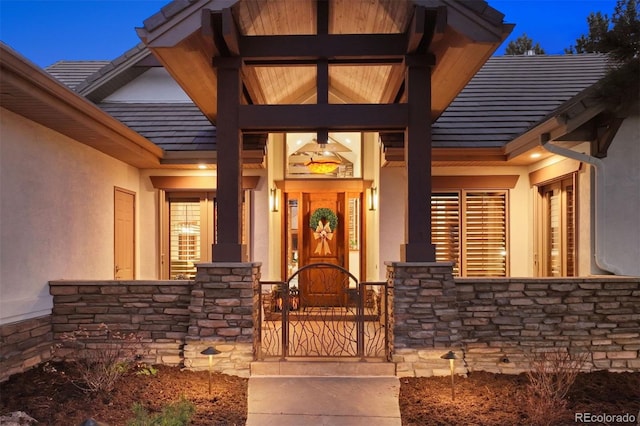 doorway to property featuring stone siding and stucco siding