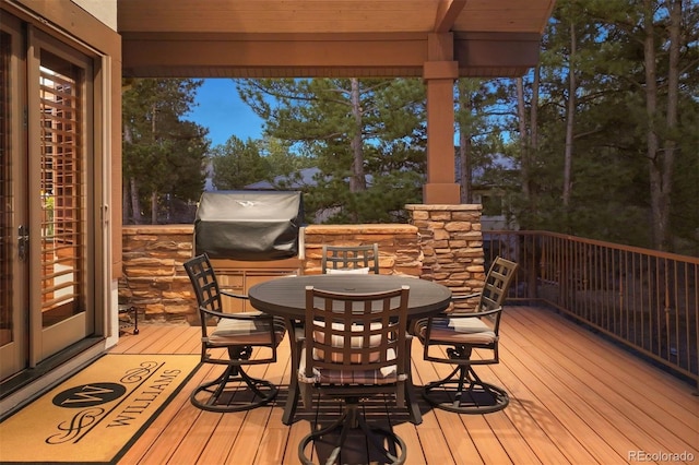 wooden terrace with outdoor dining space and area for grilling