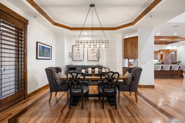 dining area featuring wood finished floors, recessed lighting, a raised ceiling, and baseboards