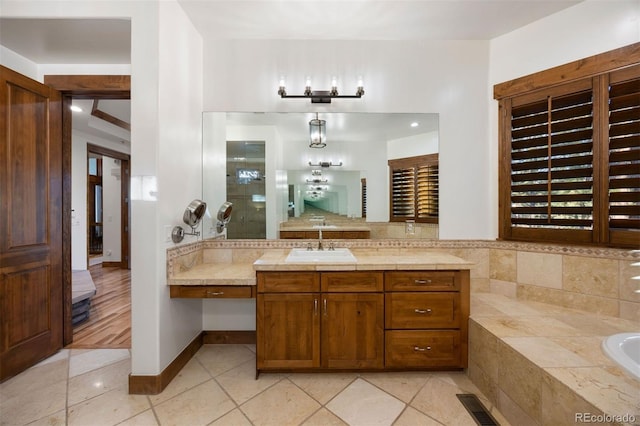 bathroom with a garden tub, tile patterned flooring, visible vents, and vanity