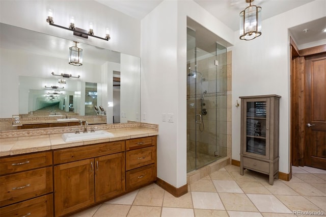 full bath with a stall shower, tile patterned floors, baseboards, and vanity