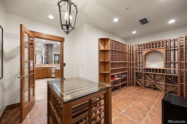 wine area with a notable chandelier, french doors, visible vents, and recessed lighting