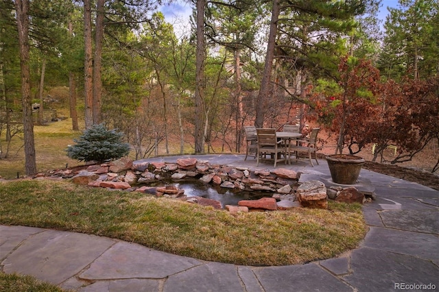 view of yard featuring a forest view and a patio area