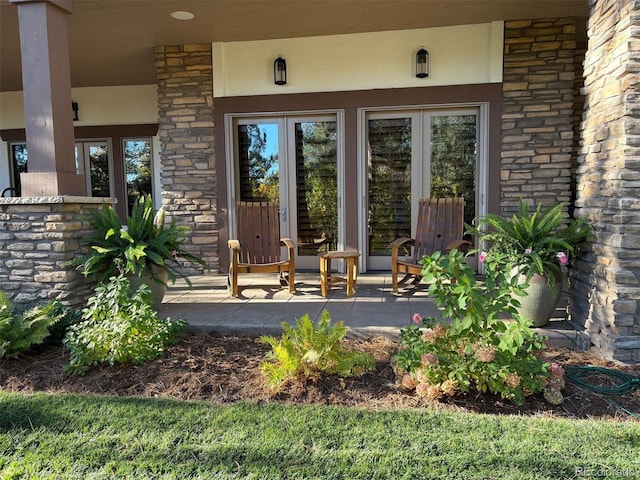 entrance to property featuring stone siding and french doors