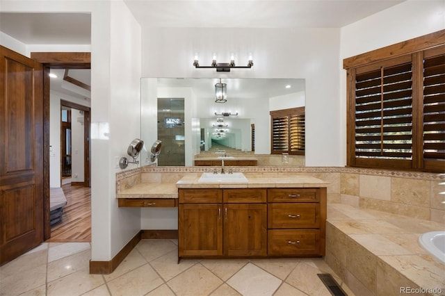 bathroom featuring tile patterned floors, a garden tub, vanity, and decorative backsplash