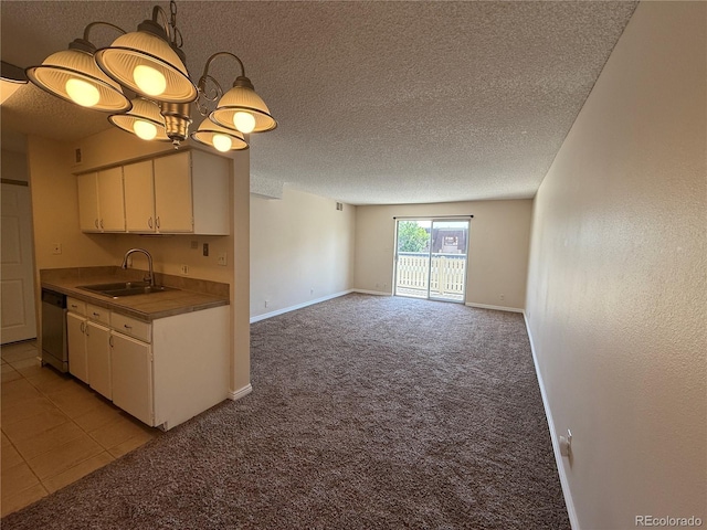 7695 E Quincy Ave Unit 207, Denver, CO 80237 - kitchen featuring stainless steel dishwasher, light carpet, a textured ceiling, white cabinets, and decorative light fixtures