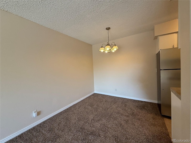 7695 E Quincy Ave Unit 207, Denver, CO 80237 - unfurnished dining area featuring carpet, a chandelier, and a textured ceiling
