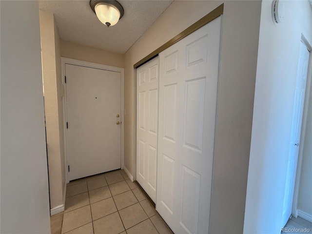 7695 E Quincy Ave Unit 207, Denver, CO 80237 - hall with light tile patterned flooring and a textured ceiling