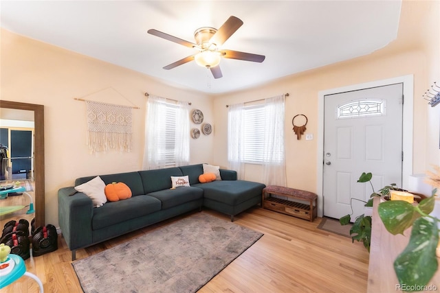 living room with light wood-type flooring and ceiling fan