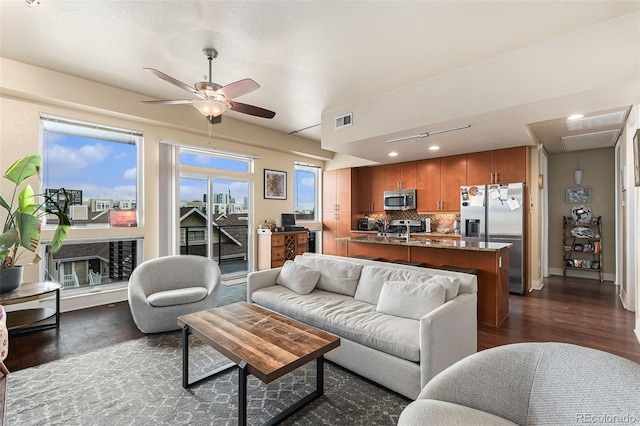 living area with dark wood-style floors, visible vents, and ceiling fan